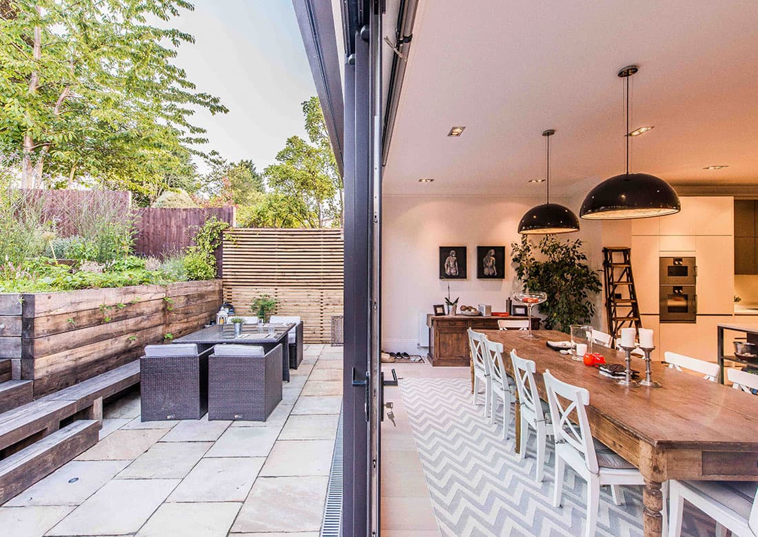 The open-plan kitchen and dining space at Crediton Hill, opening to a garden terrace